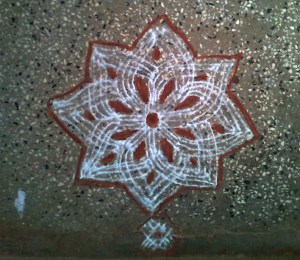 Traditional Kolam made with lines and filled with red stone color Traditional Kolam made with lines and filled with red stone color